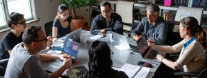 a diverse group of professionals collaborating around a table covered in laptops and charts, brainstorming creative social media strategies.